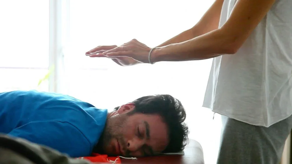 Praticien accompagnant une personne allong&eacute;e pendant un exercice de Bodhypnosis&reg;