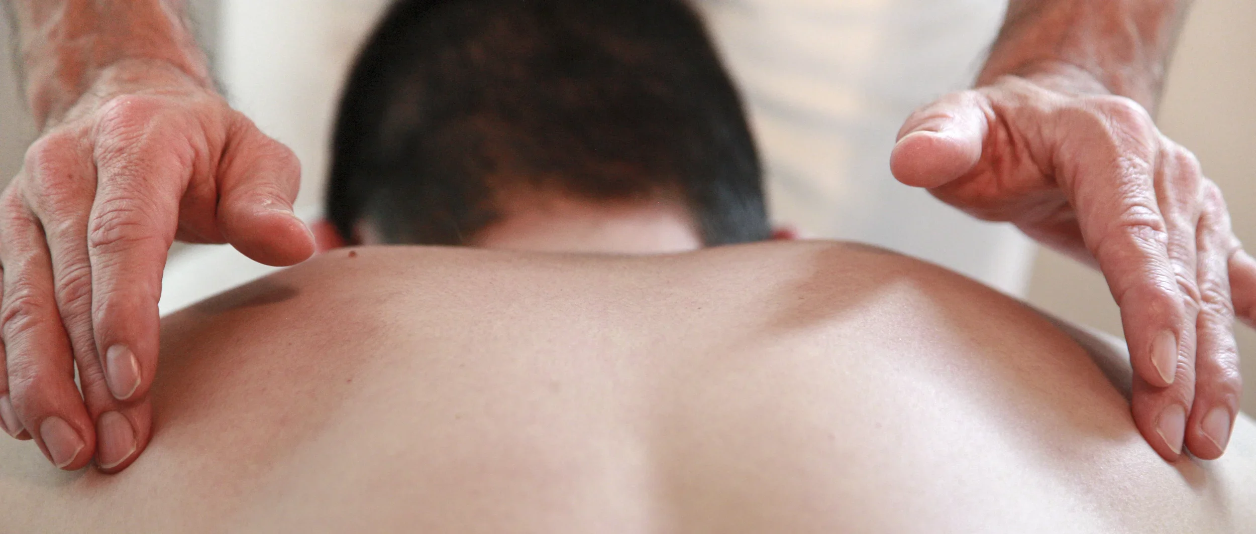 Mains d&rsquo;un praticien pos&eacute;es sur le dos d&rsquo;une personne allong&eacute;e pendant une s&eacute;ance Bodhypnosis&reg;